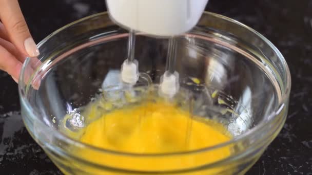 Woman confectioner beats eggs with sugar. Adding sugar to the eggs. — Stock Video