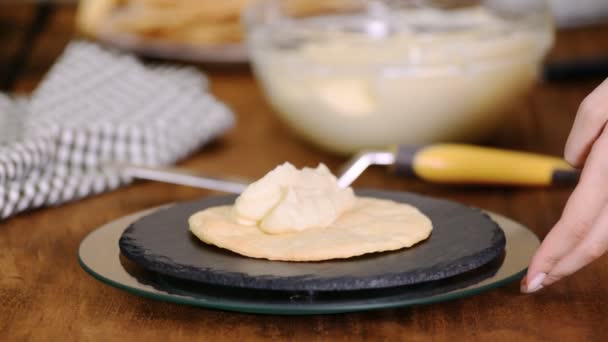 Φτιάχνοντας στρώματα από κέικ Ναπολέοντα στο σπίτι: βάζοντας κρέμα σε ψημένο γλυκό. — Αρχείο Βίντεο