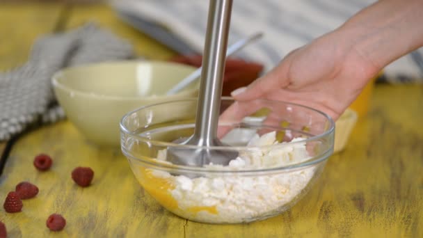 A woman blends a cottage cheese mass with a blender. — Stock Video