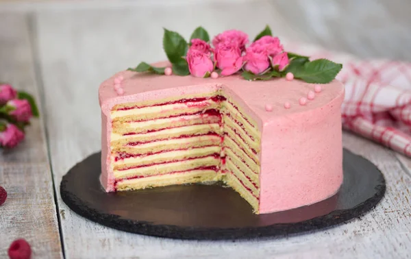 Réteges torta bogyós töltelékkel, friss rózsával díszítve. Stock Kép