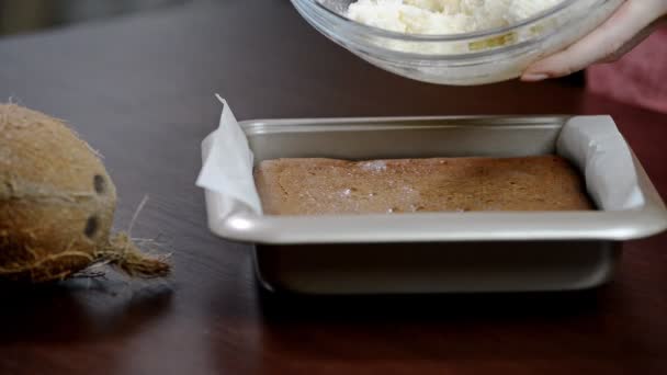 Kvinna i köket gör brownie med kokos lager och choklad ganache. — Stockvideo