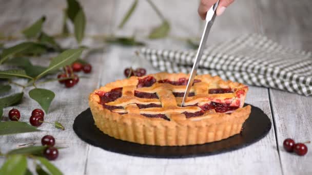 Mãos de mulher cortam uma torta de cereja caseira com uma crosta Flaky . — Vídeo de Stock