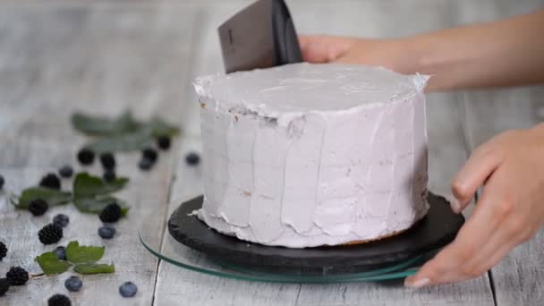 Cukiernik wygładza purpurowy krem na ciastku z łopatką do gotowania. Koncepcja domowego ciasta, ciasta gotowania. — Wideo stockowe