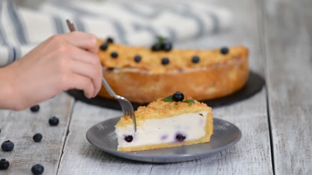 Frau isst leckeren Käsekuchen mit Blaubeeren. — Stockvideo