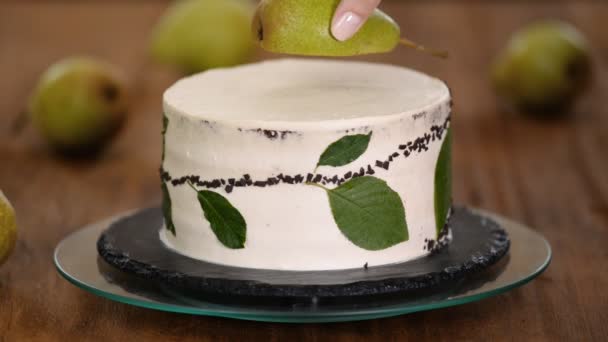 女糖果工用新鲜梨子装饰巧克力蛋糕. 自制糕点、烹调蛋糕的概念. — 图库视频影像