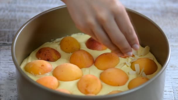 Vrouw maken van zomer abrikoos taart met amandel. — Stockvideo