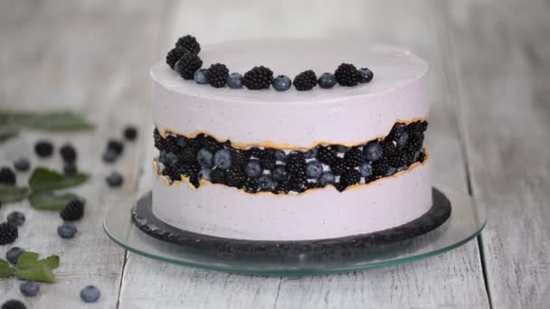 Pastelero decora un hermoso pastel con arándanos y moras . — Vídeos de Stock