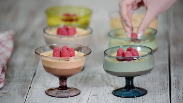 Raspberry with chocolate mousse in glass cups on a wooden background. Cream, sweetness. — Stock Video