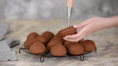 Çikolatalı profiterolleri kremayla dolduran bir şef..