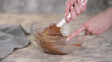 Evde çikolatalı choux hamur işi yapmak için malzemeleri karıştırıyorum..