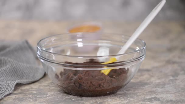 Preparação de massa de chocolate choux na tigela. Adicionar ovos à massa . — Vídeo de Stock