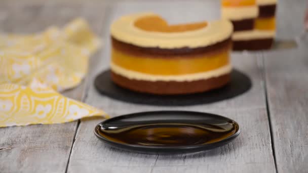 Pedazo de pastel de esponja de chocolate casero con mousse de melocotón y jalea . — Vídeo de stock