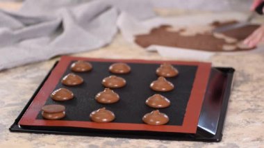 Pasta şefi çiğ profiterolleri çikolatalı kısa hamur işiyle süslüyor..