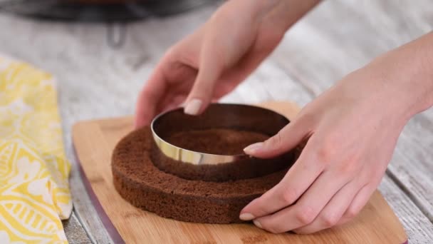 Manos femeninas cortando el bizcocho con un anillo de confitería . — Vídeos de Stock