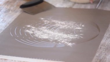 Hamurla çalışan bir kadın. Bir iş yüzeyine maya hamuru koymak.