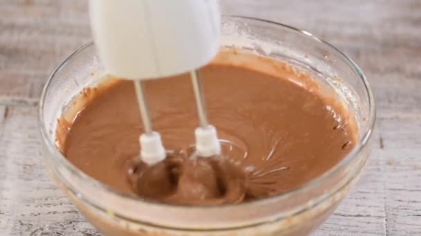 Keukenmixer zweept chocoladebeslag in kom. Close-up. — Stockvideo