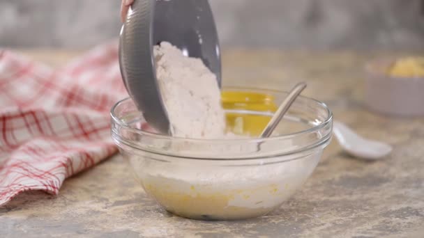 Chef prépare la pâte pour la cuisson. Ajouter de la farine dans un bol en verre . — Video