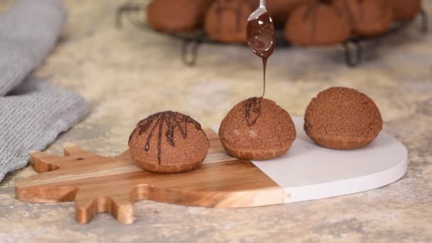 Γαλλικό επιδόρπιο Σοκολάτα Choux au Craquelin. Ρίχνουμε σοκολάτα πάνω από τα προφιτερόλ. — Αρχείο Βίντεο