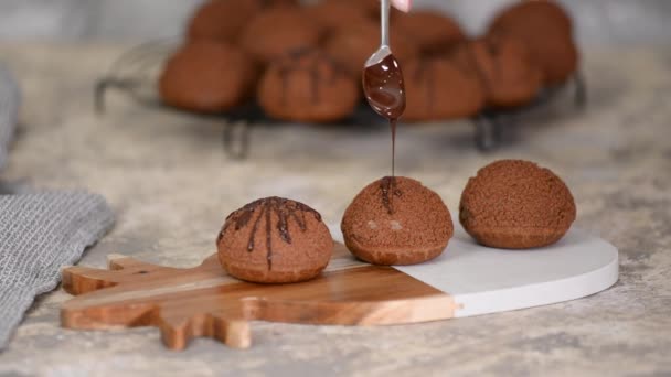 Sobremesa francesa Chocolate Choux au Craquelin. Despejando chocolate sobre os profiteroles . — Vídeo de Stock