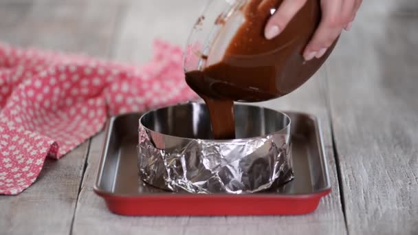 Vrouwen handen gieten taart beslag in taartvorm, klaar om te bakken. — Stockvideo