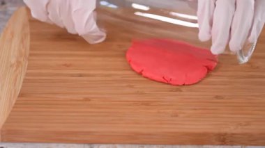 Masada şişeyle şeker mastiği yuvarlayan bir kadın..