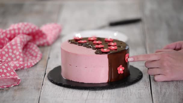 Mains féminines décorer gâteau de mousse de fraise maison avec des fleurs de sucre . — Video