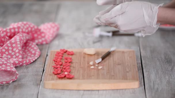 여성 이 케이크 장식을 위해 분홍색 꽃을 만들고. — 비디오