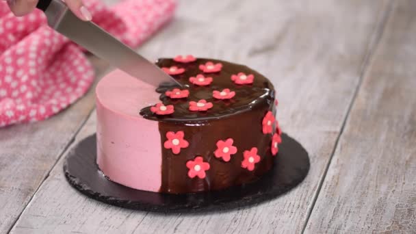 Découpe d'un gâteau à la mousse aux fraises avec glaçure miroir . — Video