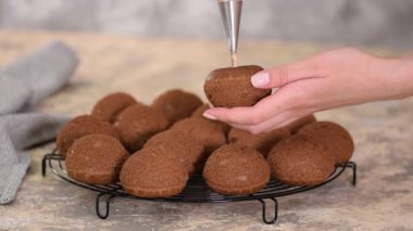 Çikolatalı profiterolleri kremayla dolduran bir şef..