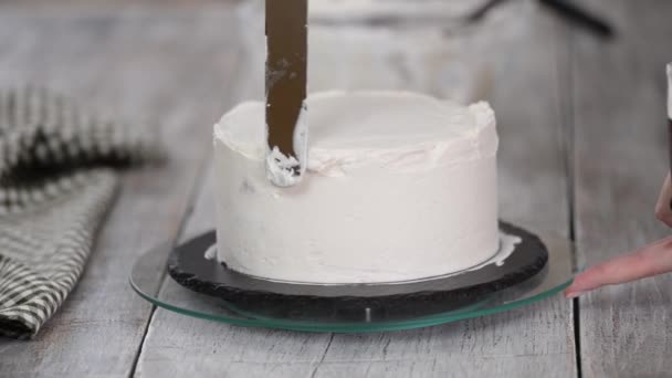 A confectioner prepares a cream cake. Dessert on a white table in the kitchen. The concept of home baking, cooking cakes. — Stock Video