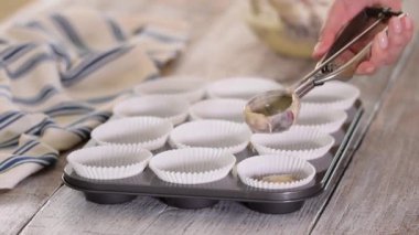 Çörek bardaklarına yabanmersini hamuru döküyorum. Yaban mersinli kek pişiren kadın.