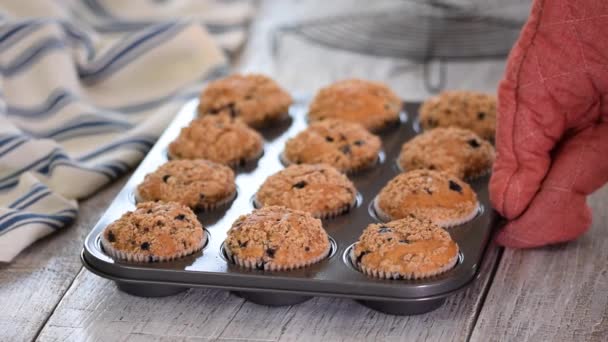 Frau mit frisch gebackenen Blaubeermuffins in Küche. — Stockvideo