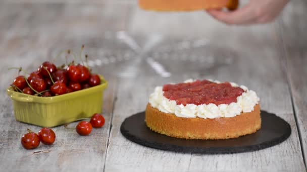 Femme faisant le gâteau cerise nue avec crème vanille. — Video