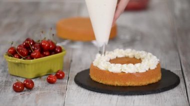 Kirazlı pastayı pasta poşetindeki kremayla süslüyorsun..