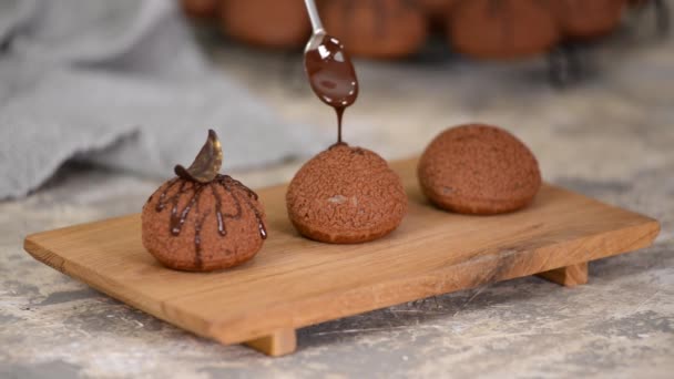 Französisches Dessert Chocolate Choux au Craquelin. Die Profiteure mit Schokolade überschütten. — Stockvideo