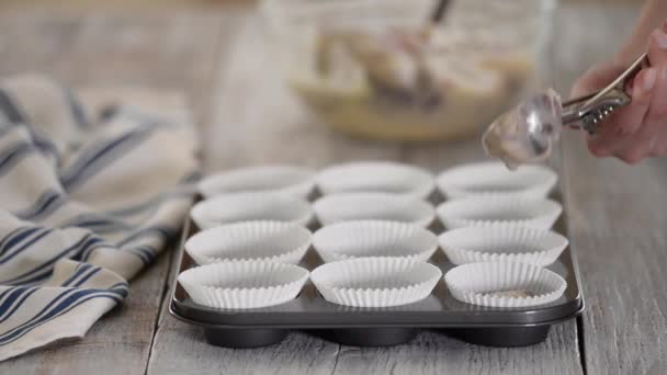 Nalít borůvkový těsto do muffinových pohárků. Ženské borůvkové muffiny — Stock video