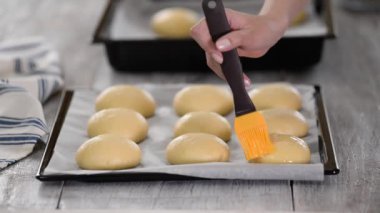 Çiğ çörekleri yumurta sarısında fırçalamak.