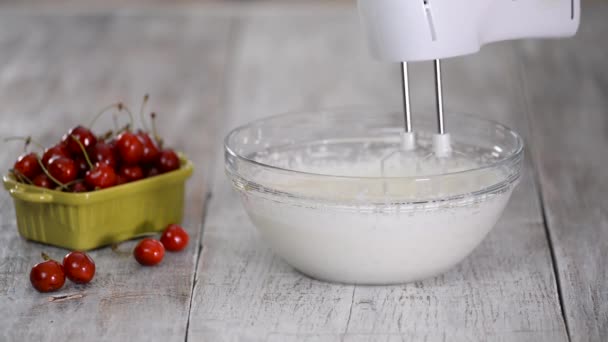 Fouetter la crème avec un mélangeur pour faire un dessert. — Video