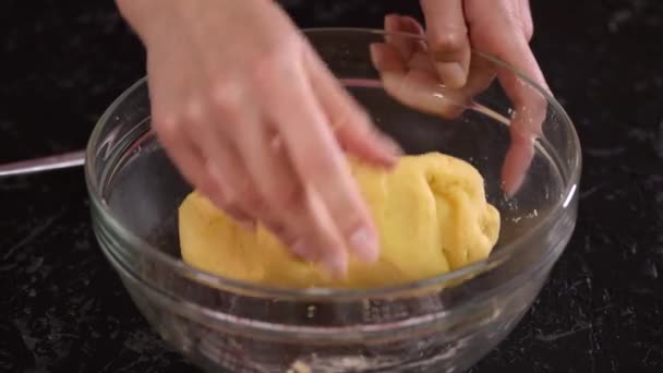 Samičí ruce hnětají těsto v kuchyni. Detailní záběr. — Stock video