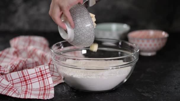 Preparación de ingredientes para hornear. Las manos femeninas añaden mantequilla al tazón con harina . — Vídeos de Stock