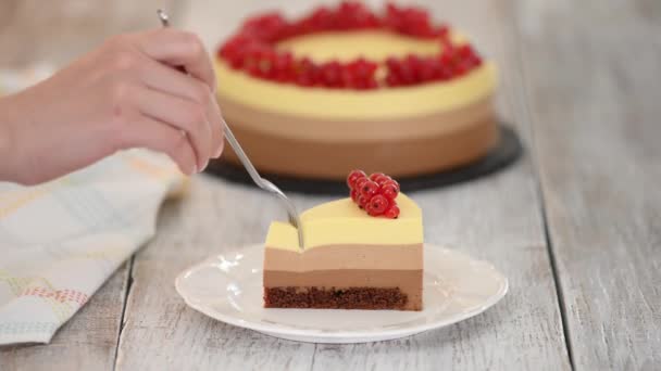 Biten av trippel choklad mousse kaka med röda vinbär. — Stockvideo