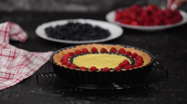 Puding ve böğürtlenli tart yapan kadın. Çilekli tart..