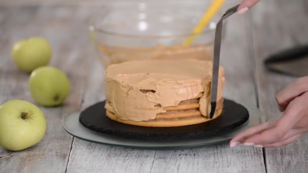 Proces dekoracji tortu z karmelową okładką kremową. — Wideo stockowe