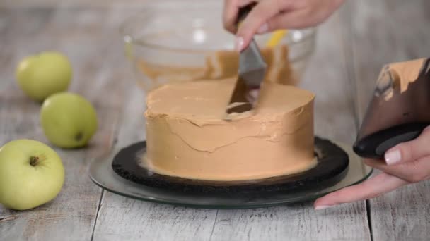 O processo de decorar um bolo com cobertura de creme de caramelo. — Vídeo de Stock
