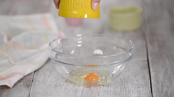 Whisking tojás és cukor egy üvegtálban. — Stock videók