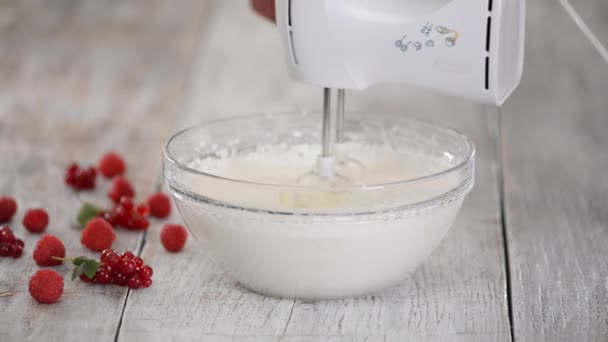 Pasticcere aggiungendo purea di bacche in panna montata. Battere con una crema di bacche mixer. — Video Stock