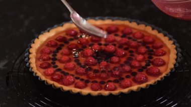 Meyveli ve jöleli kremalı tart yapan kadın. Çilekli tart..