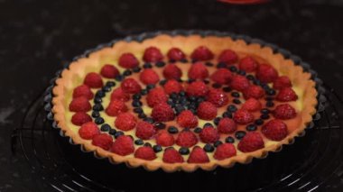 Meyveli ve jöleli kremalı tart yapan kadın. Çilekli tart..