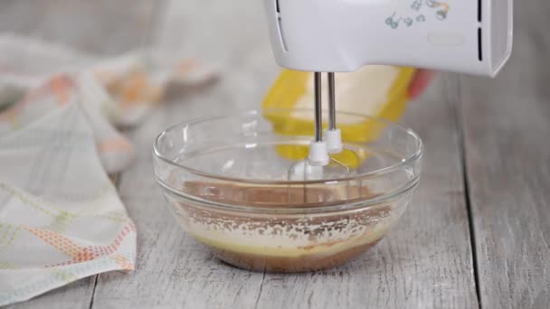 Vařit přidejte mouku do skleněné misky s těstem. Míchání těsta v misce s motorovým mixérem. — Stock video