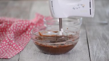 Çikolata hamuru karıştırmak veya kek, kurabiye, pasta yapmak için hamuru karıştırmak. Karıştırıcı çikolatayı kasede dövüyor.